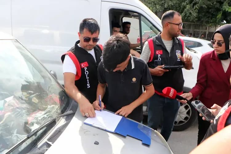 Adana'da sulama kanalından çıkarılan gence polis ekipleri tarafından ceza tutanağı imzalatılırken çekilen fotoğraf.