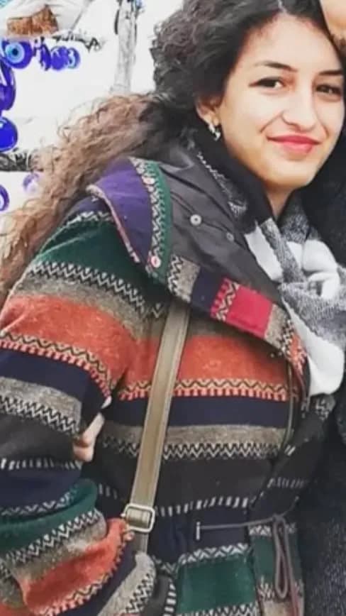 Renkli desenli hırka giyen genç kadının gülümsediği portre fotoğrafı
