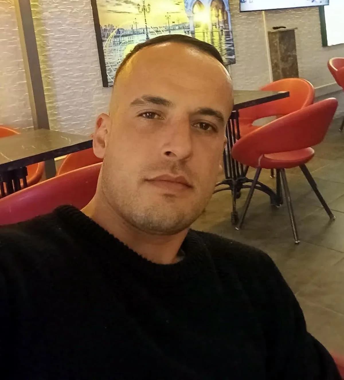 Melih Ertekin bir mekanda oturarak çekilmiş fotoğrafında