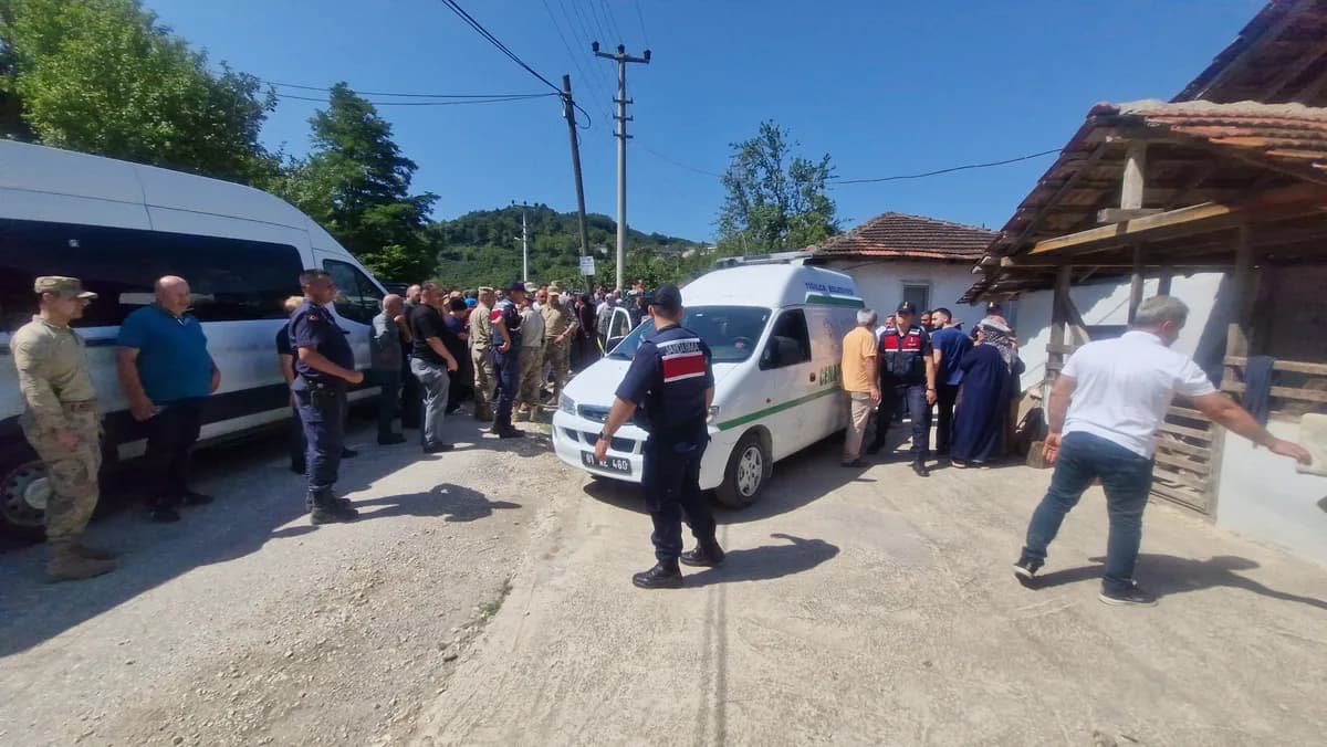 Köy yolunda cenaze aracı çevresinde bekleyen jandarma, asker ve köylüler