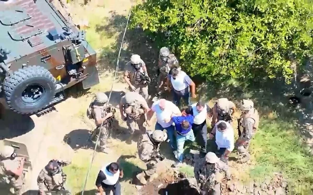 Kırsal alanda zırhlı araç yanında güvenlik güçlerinin bir kişiyi gözaltına aldığı havadan çekim