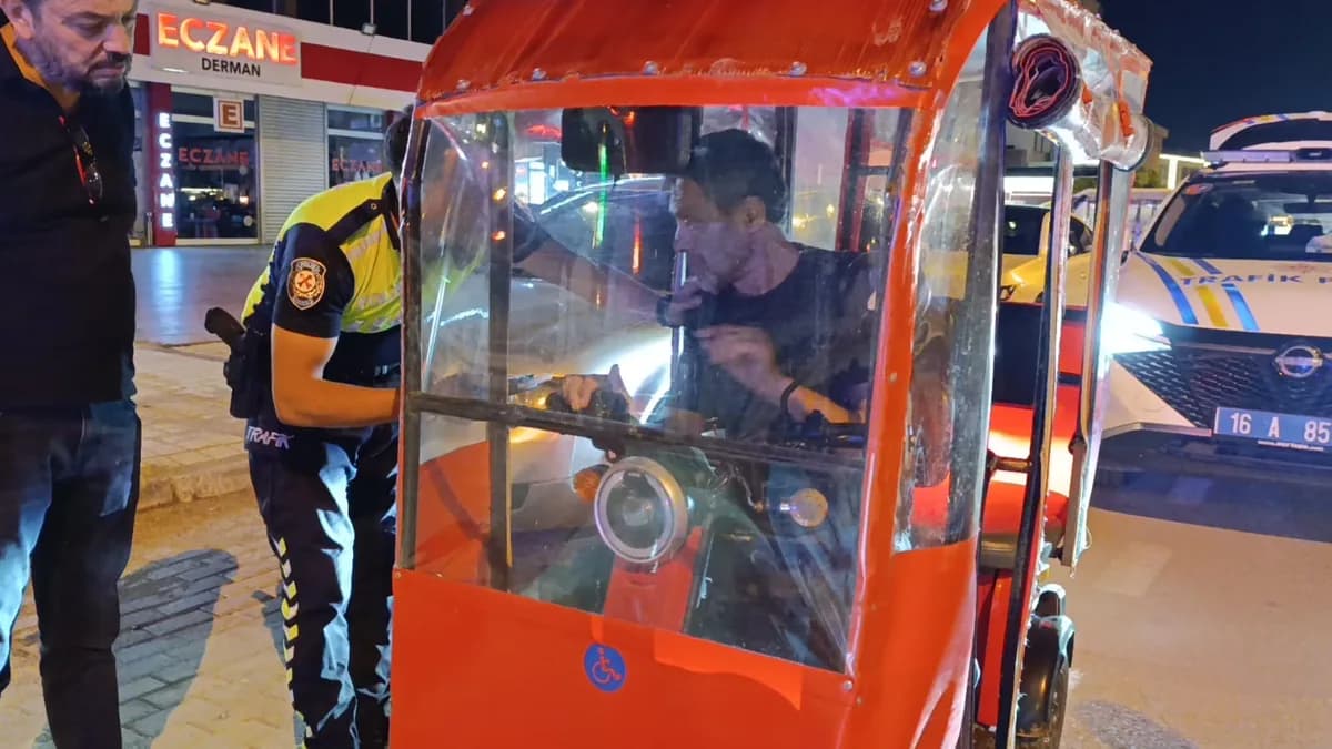 Gece yapılan denetimde trafik polisi, kırmızı kapalı yük motosikletindeki sürücüyle konuşuyor