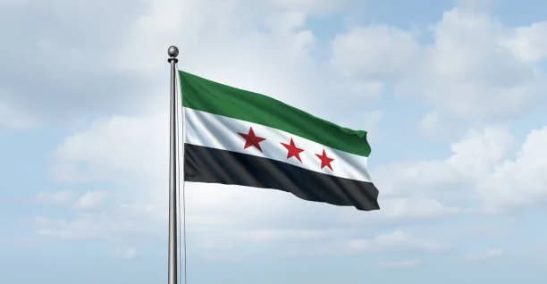 Gökyüzü önünde dalgalanan yeşil-beyaz-siyah üç yıldızlı Suriye bayrağı