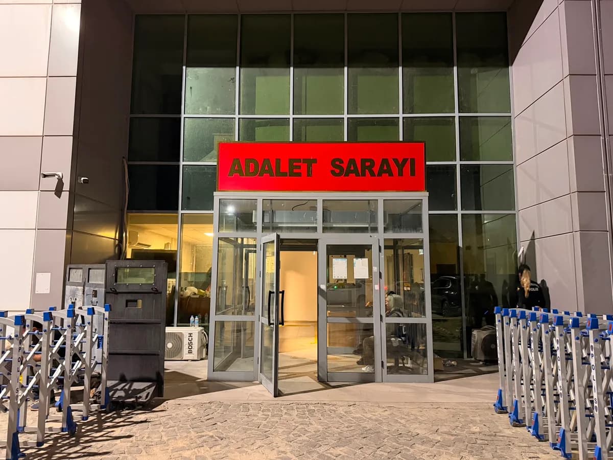 Gece çekilmiş kırmızı Adalet Sarayı tabelalı adliye binası girişi ve polis bariyerleri