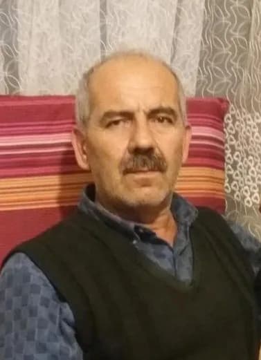 Bıyıklı, orta yaşlı bir erkeğin ev ortamında çekilmiş vesikalık portresi