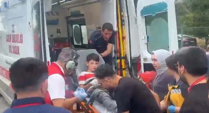 Sedyedeki yaralı çocuk sağlık ekipleri tarafından ambulansa taşınırken